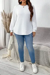 Detailed view of white plus size waffle knit pullover with a stylish curved hem design