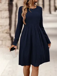 Vista detallada de vestido midi azul marino de manga larga con textura plisada y corte A