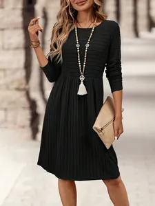 Detalle de un vestido midi negro de manga larga texturizado con un collar boho