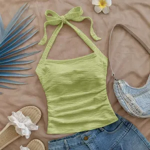Top corto verde claro con cuello halter y tejido con textura ondulada para verano.