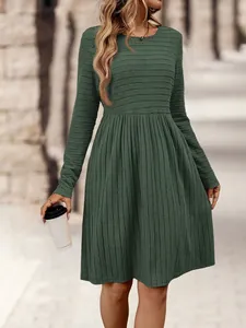 Vista detallada de vestido plisado de canalé verde oscuro con manga larga en la ciudad