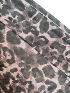 Gros plan détaillé d'un tissu en maille semi-transparent à imprimé léopard pour femme.