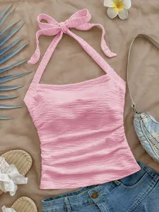 Vista detallada del top rosa texturizado con cuello halter y lazo muy elegante