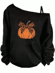 Close-up detail of black off-the-shoulder sweatshirt with pumpkin and leopard bow print