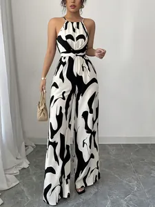 Detailansicht eines eleganten, schwarz-weiß bedruckten Halterneck-Jumpsuits mit weitem Bein