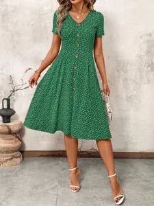 Full-length view of a green button-down polka dot summer dress with a deep V-neckline