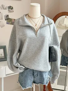 Detailed front view of a grey half-zip oversized fleece sweatshirt styled on mannequin