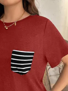 Primer plano de una camiseta roja de manga corta con un elegante bolsillo de rayas blancas y negras.
