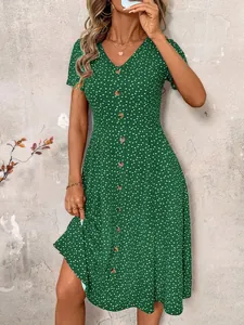 Detail view of a stylish green V-neck button-down dress featuring white heart patterns.
