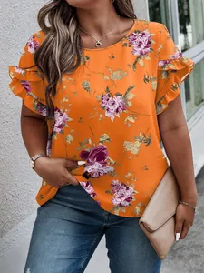 Detail of orange floral blouse featuring elegant ruffle sleeves and vibrant print.