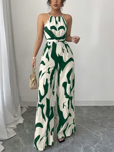 Eleganter Neckholder-Jumpsuit mit dunkelgrünem Abstraktmuster und weitem Beinschnitt.