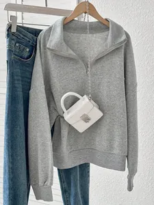 Detailed view of a grey half-zip fleece sweatshirt with loose lapel and ribbed cuffs.
