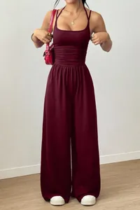 Elegante tuta bordeaux a doppia spallina con gamba larga e vita snellente.