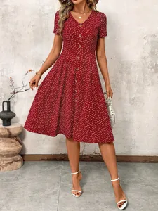 Full body view of a stylish red polka dot midi dress featuring a V-neck and button-down front.