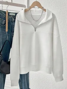 Detail of white oversized half-zip sweatshirt featuring a fleece lining for winter warmth