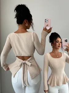 Detailed macro view of beige ribbed knit long sleeve top featuring backless bow tie design
