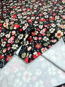 Detailed macro view of vibrant floral print and stitching on women's dress fabric