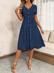 Close-up of a navy blue V-neck midi dress with white heart polka dots and front buttons.