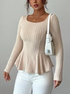 Close-up detail of a beige ribbed knit long sleeve top featuring a stylish peplum hem design