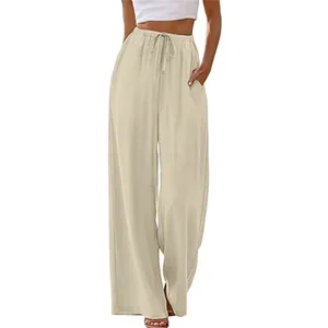 Detail of beige wide-leg pants featuring an elastic waist, drawstring, and side pockets.
