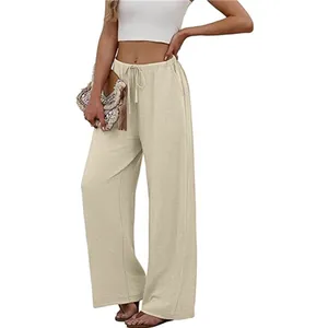 Detailed view of beige wide-leg pants featuring elastic drawstring waist and side pockets.