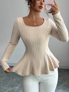 Detailed view of beige ribbed knit peplum top showing fabric texture and flared hemline