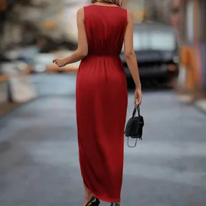 Back view of a red satin sleeveless maxi dress with a slit hem in an urban street.