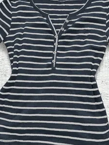 Close-up of V-neck button detail on women's striped slim fit long-sleeve T-shirt.