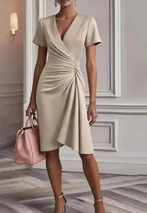 Close-up detail of an elegant beige V-neck dress with sophisticated pleated waist design
