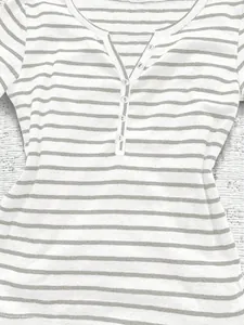Detailed macro view of the v-neck and button placket on a striped casual long-sleeve top