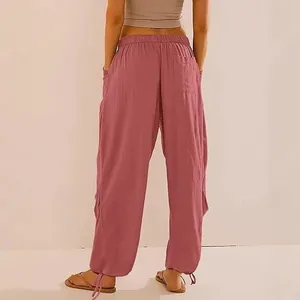 Dettaglio di pantaloni jogger rosa ampi con vita elastica e coulisse alle caviglie