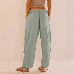 Dettaglio di pantaloni jogger verde salvia a gamba larga con vita elastica e coulisse