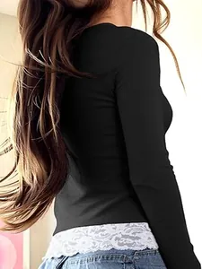 Close-up detail of black ribbed long-sleeve top with white lace patchwork hem