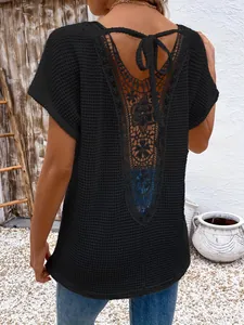 Detailed back view of a black short-sleeve top featuring intricate floral lace and ties