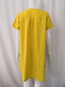 Back view detail of a loose yellow cotton linen casual dress showing the yoke and pleat