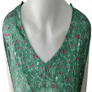 Gedetailleerde macro-opname van een groene mouwloze zomerse bloemenblouse met V-hals