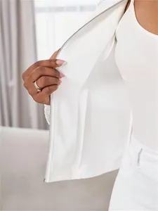 Gros plan détaillé de la fermeture éclair d'une veste blanche à manches dentelle.