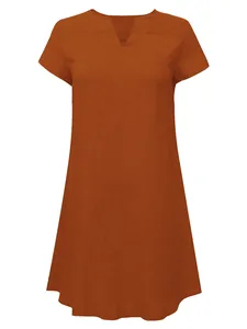 Close-up of rust-colored woven dress showing V-neckline and textured fabric detail.