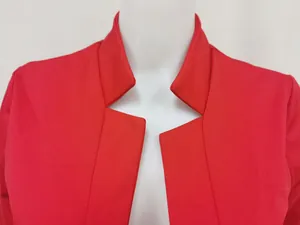 Gedetailleerde close-up van de unieke revers van deze rode open blazer op mannequin