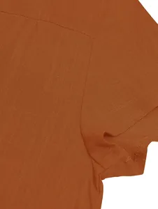 Macro view showing the fine texture and shoulder seam of the orange woven dress fabric.
