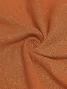 Detailed close-up of burnt orange woven fabric texture for lightweight summer dress