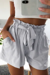 Close-up detail of high-waisted paperbag shorts with a tie belt and pockets.