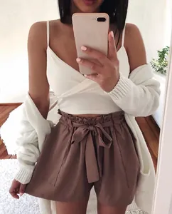 Detailed view of high waisted brown shorts featuring a stylish decorative bow belt