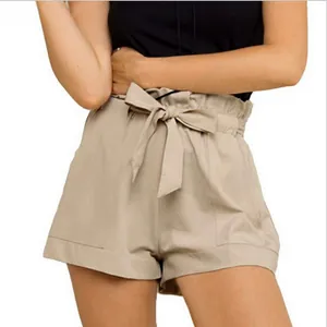 Detail view of high-waisted khaki paper-bag shorts with adjustable tie belt and side pockets