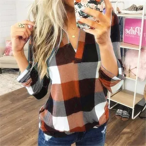 Close-up view of a stylish orange and black plaid V-neck long sleeve shirt for women