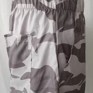 Close-up of grey camouflage print shorts with elastic high waist and side pockets.