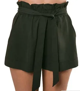 Close-up of high-waisted paperbag shorts with a matching tie belt in dark green finish.