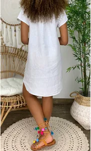 Back view of white linen short sleeve dress with loose casual fit and bohemian style details