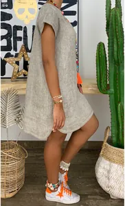Detailed side view of a stylish grey loose linen cotton dress with boho accessories