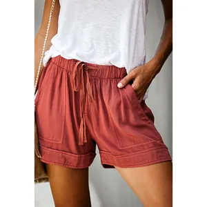 Detail view of women's rust red high-waisted casual shorts with drawstring waist